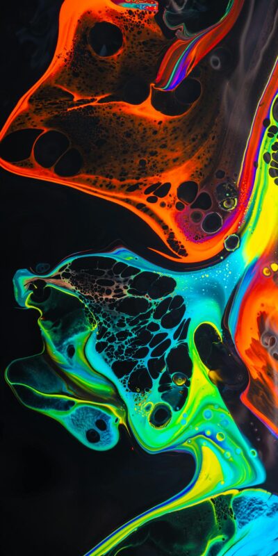 Colorful mix of neon paints swirling on black surface